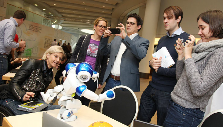 Humanoider Roboter Nao und Besucher.